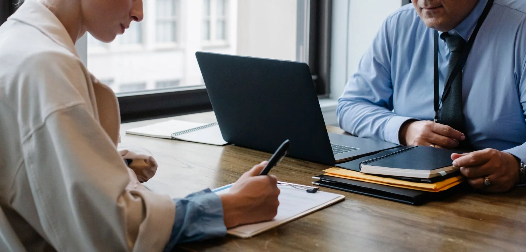 Two professionals reviewing documents and operational details together at a desk